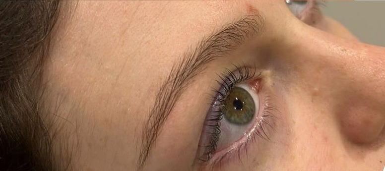 The same eye after a lash lift and tint, with lifted, curled and darker lashes