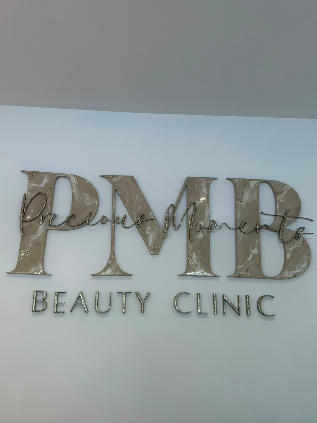 PMB Precious Moments Beauty Clinic gold and marble wall signage inside the Banstead clinic